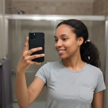 Woman taking a mirror selfie in a bathroom