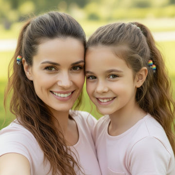 Woman and young girl with rainbow hair clips smiling outdoors