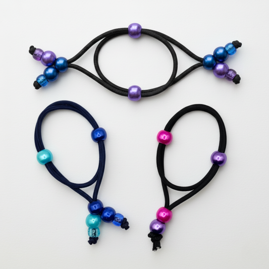 Three hair ties with colorful beads on a light gray background