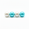 Two white pearls and two turquoise pearls on a white background