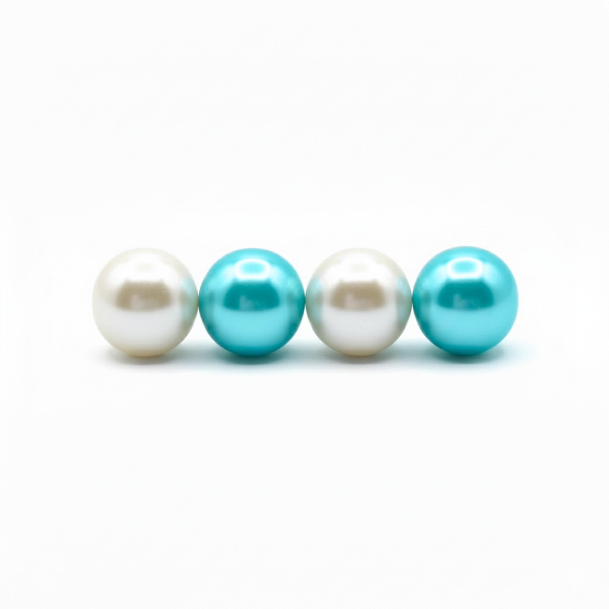 Two white pearls and two turquoise pearls on a white background