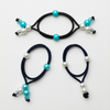 Three black hair ties with beads on a white background