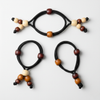 Three black hair ties with multicolored beads on a white background