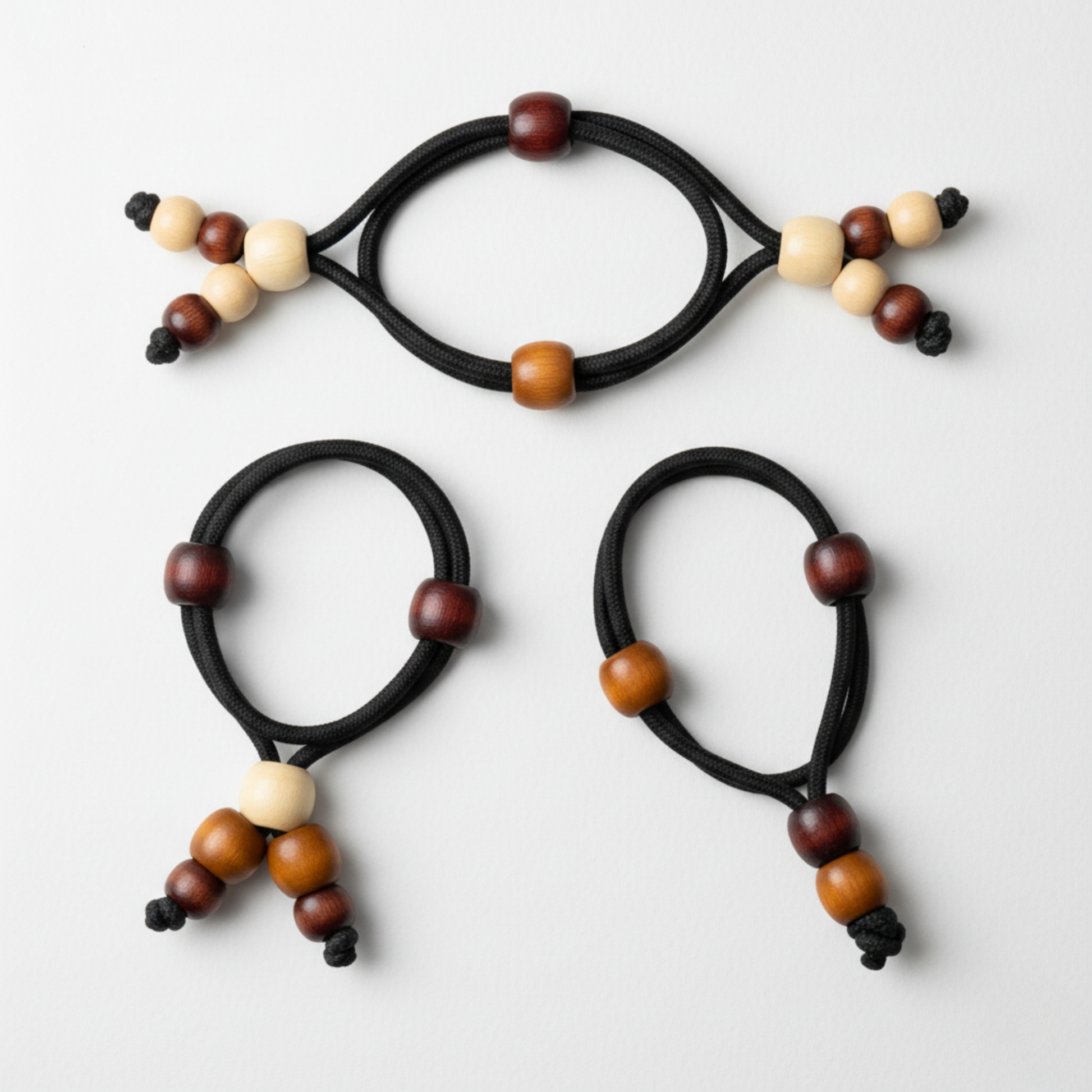 Three black hair ties with multicolored beads on a white background