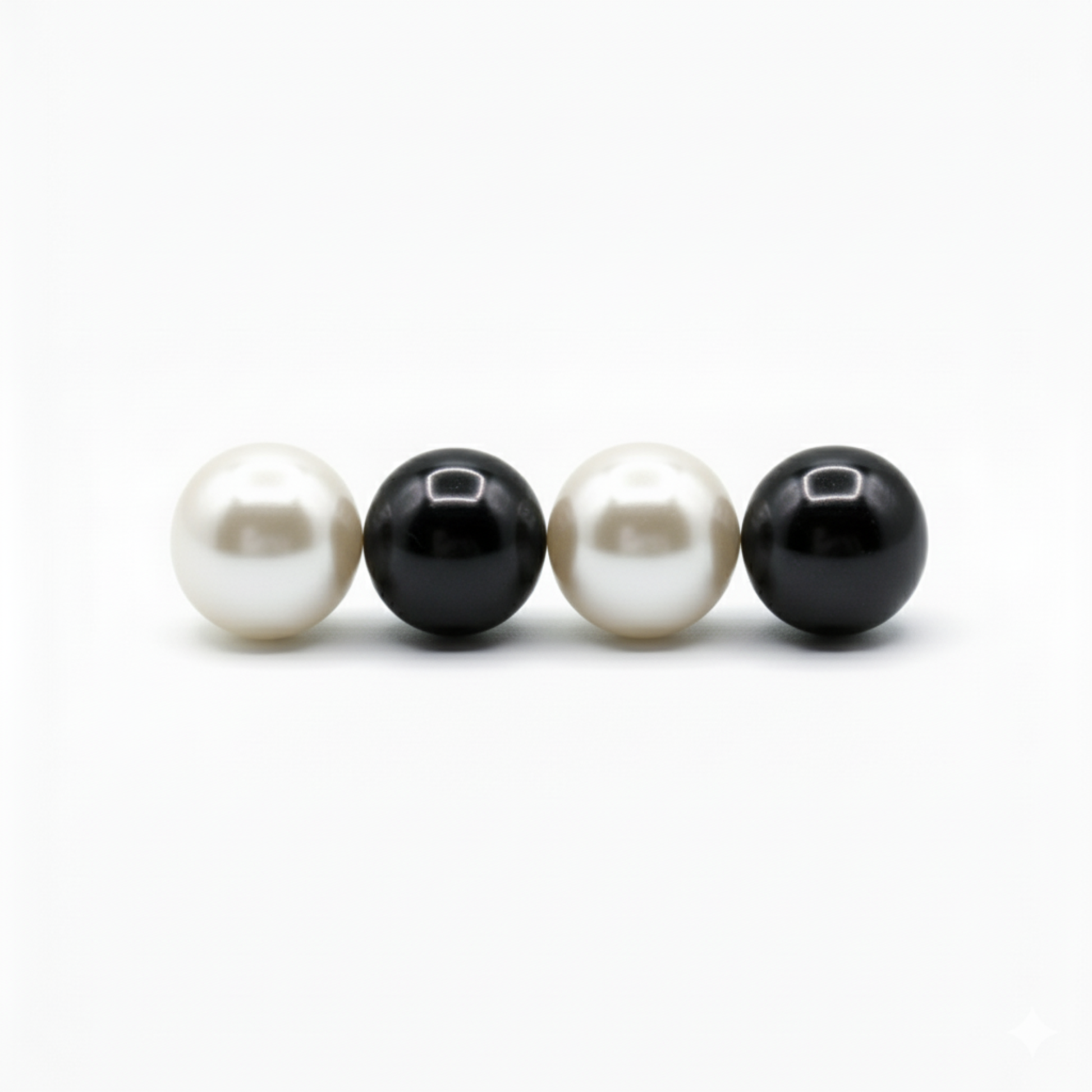 Two white pearls and two black pearls on a white background