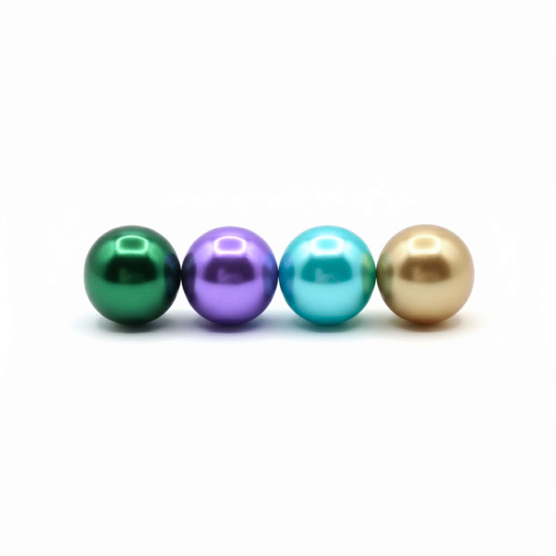 Four colored pearls (green, purple, blue, gold) on a white background