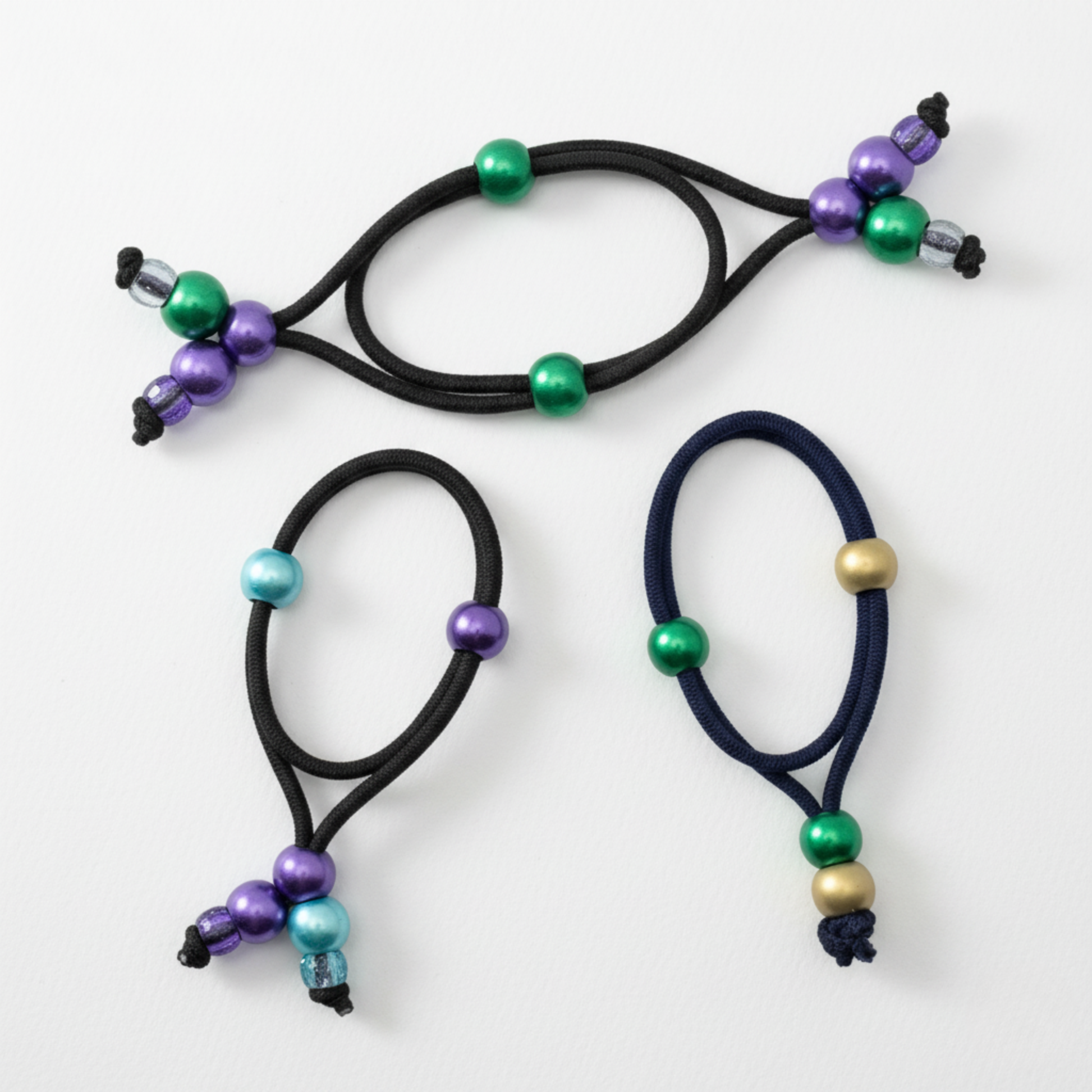 Three hair ties with colorful beads on a white background