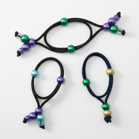 Three hair ties with colorful beads on a white background