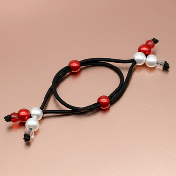 Black cord with red and white beads on a beige background