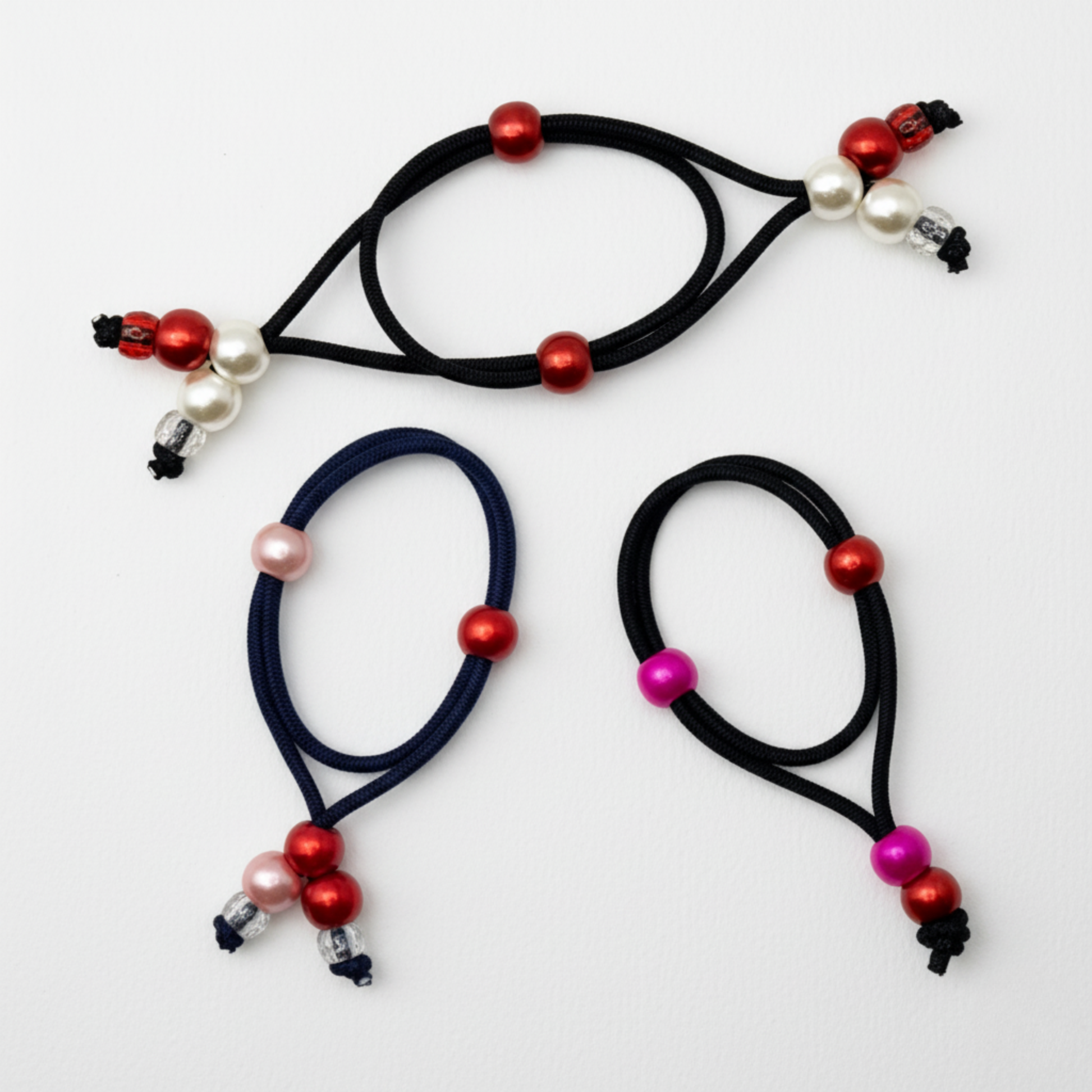 Three hair ties with colorful beads on a white background