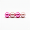 Four pink pearls of varying shades on a white background