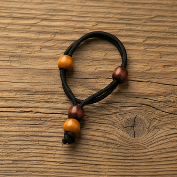 Black hair tie with wooden beads on a beige background