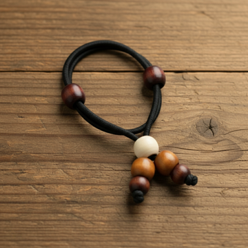 Black hair tie with wooden beads on a beige background