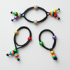 Three black hair ties with colorful beads on a white background
