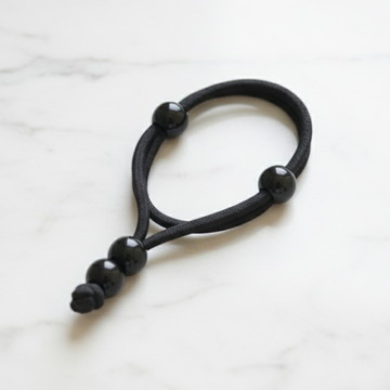 Navy hair tie with pearls on a marble background