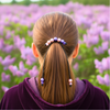 Person with a ponytail in a field of purple flowers